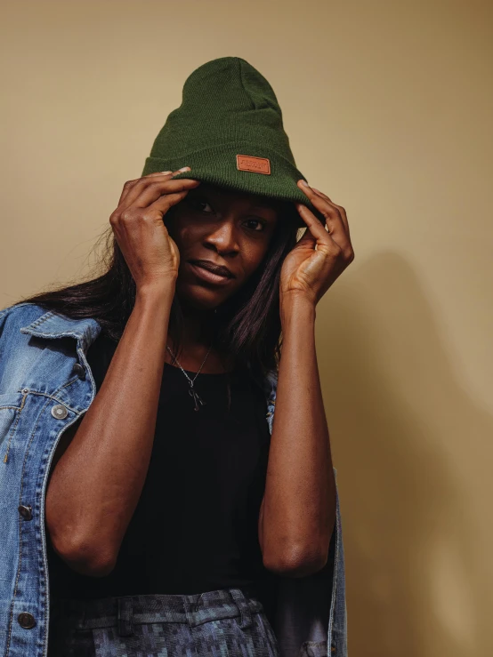 a black person holding a hat up to his face