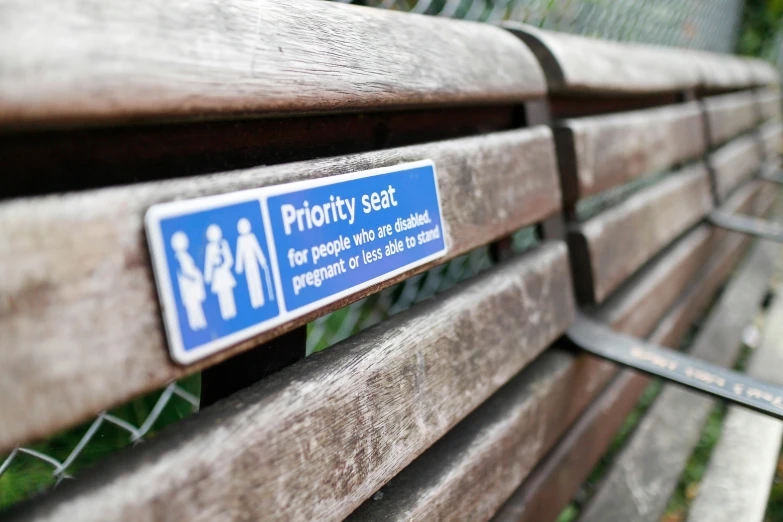 two park benches with an important sign placed on them