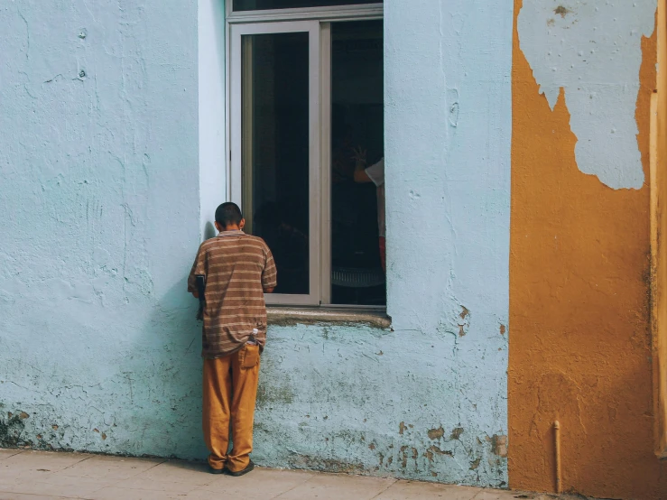 a boy looking out of the window of an old building