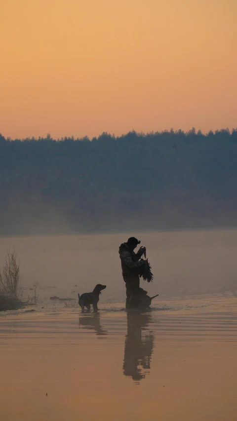 a couple in water with a dog on a foggy day