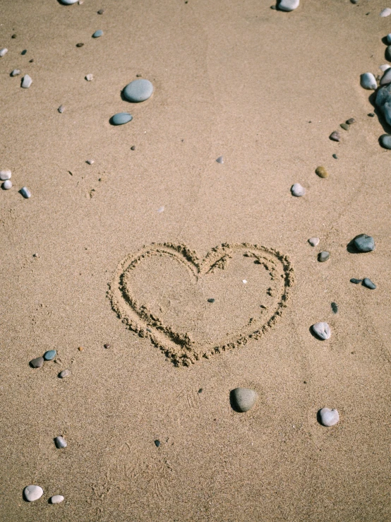 the heart drawn in the sand on the beach