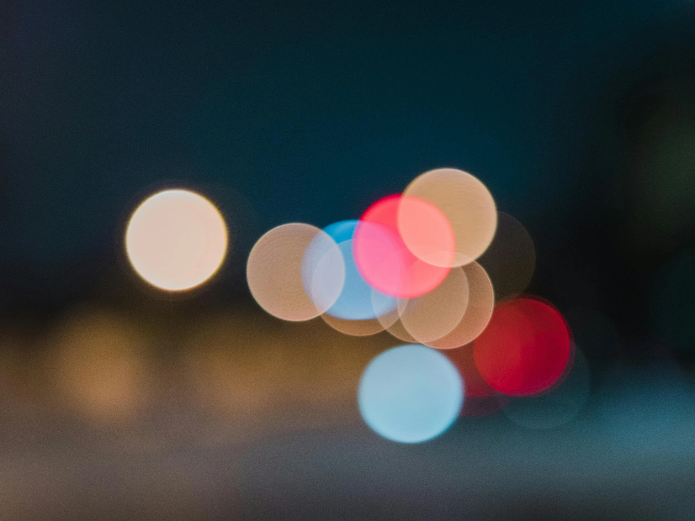 blurred traffic lights in front of an image of the street