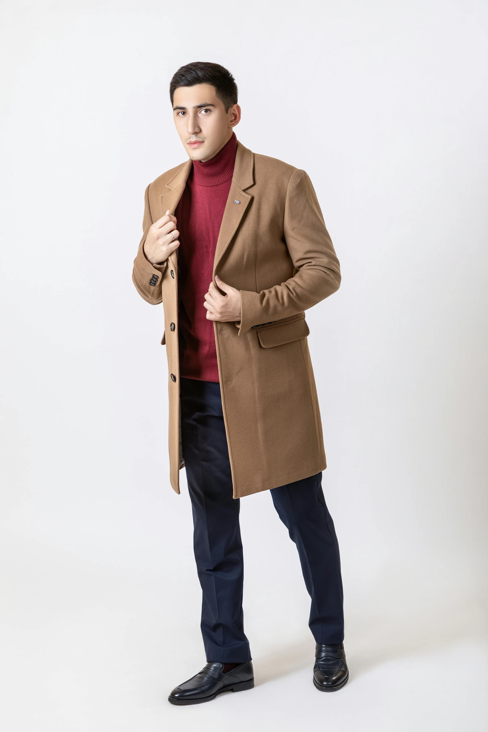 a man is dressed in a coat, sweater, pants and shoes