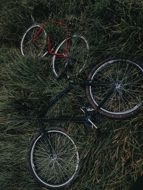 a bicycle laying on the grass in a field