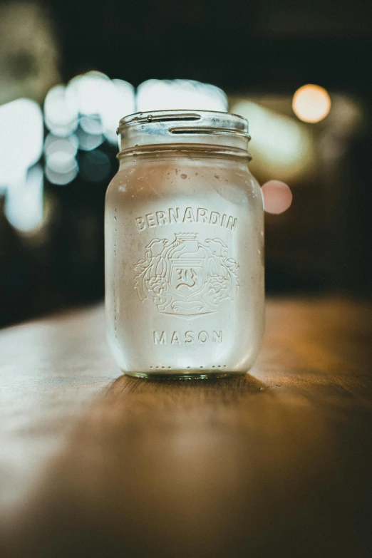 a jar of water sitting on a table in a dark room