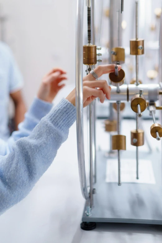 a woman with a blue sweater is using a metal rack