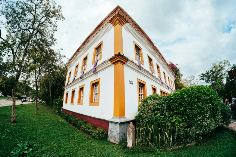 an orange and white building with plants near the side of it