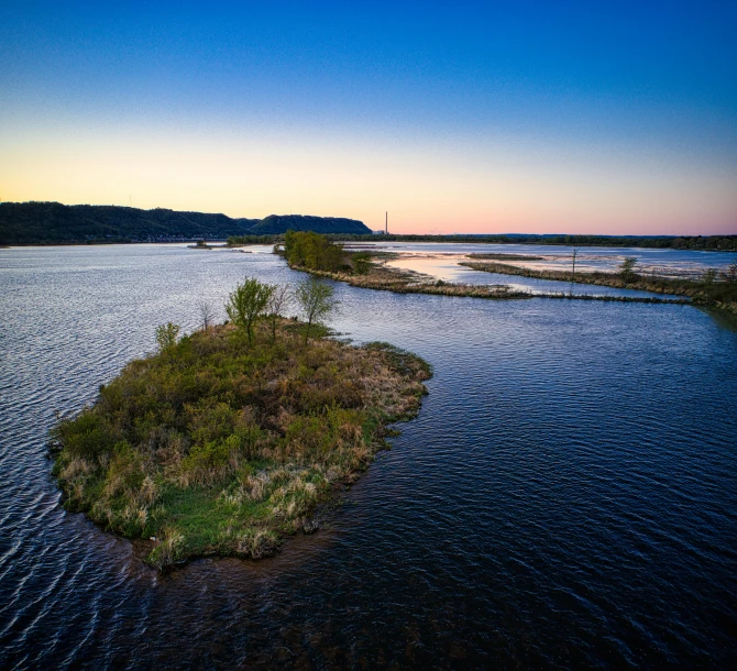 a lone tree sits in an island with water surrounding it