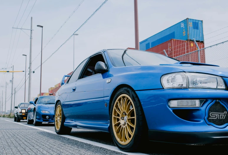 a car that is blue with some gold rims on it