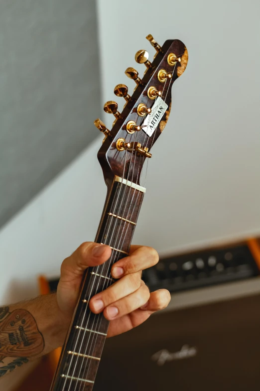 a person's hand holding an electric guitar