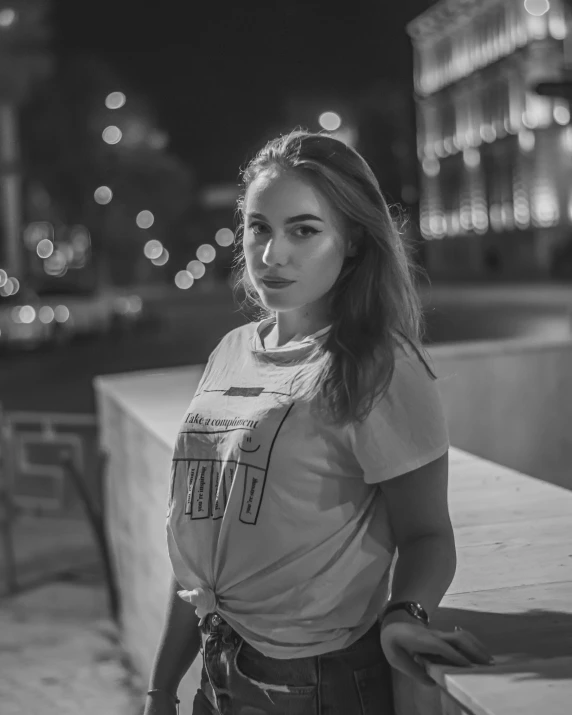 black and white image of young woman standing with her hands on hips