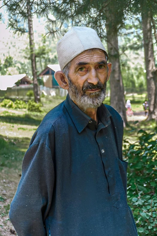 a man wearing a hat is standing in the grass