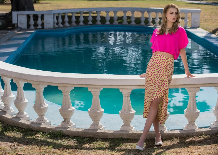 a woman standing in front of a pool posing