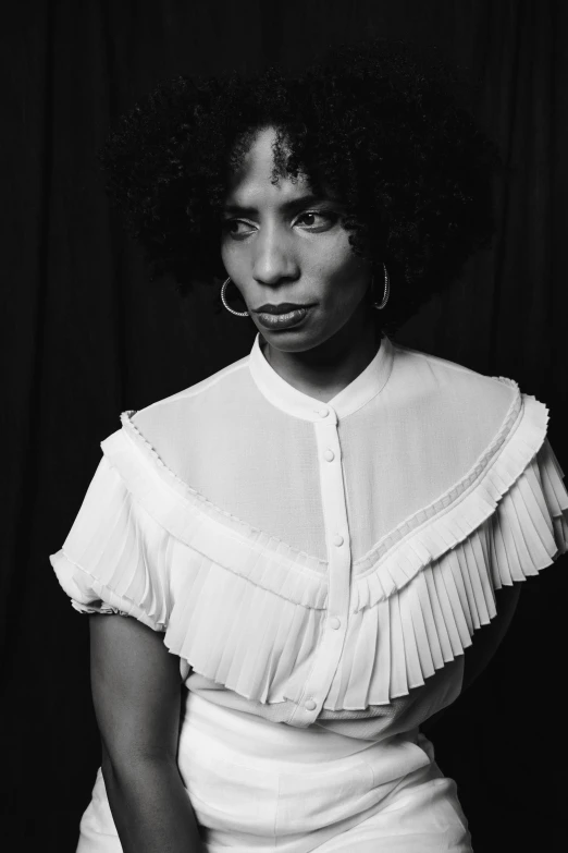 a woman with an afro is posing for the camera