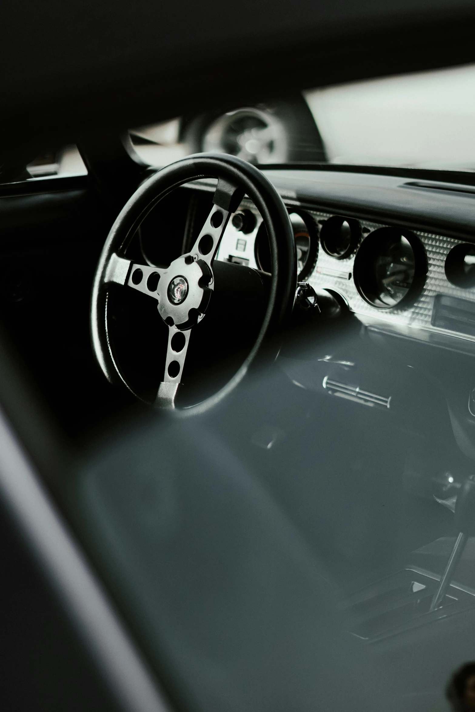 a steering wheel on an old car and a dashboard