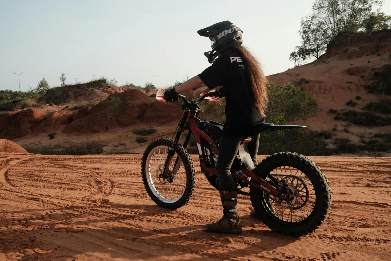 a person on a dirt bike standing in the dirt