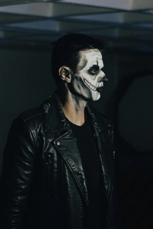 a man with black face and white makeup, looking to his right