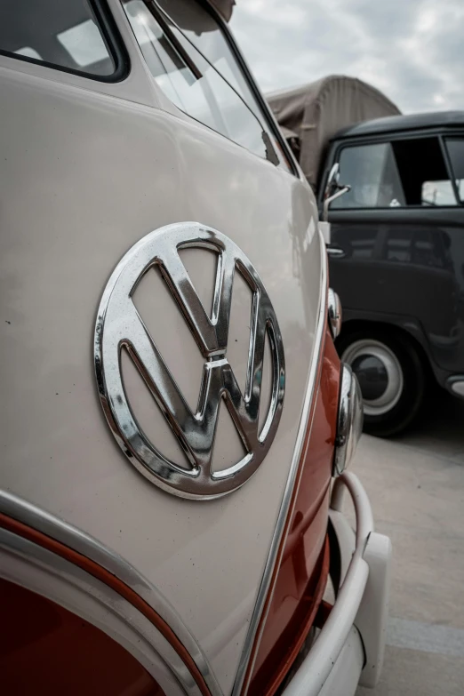 close up of a vw van in a parking lot with another vw car