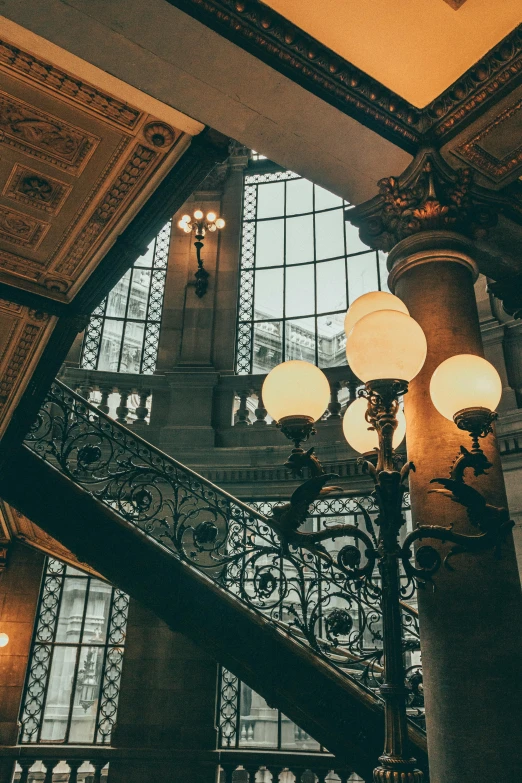 a clock sitting under two glass windows next to stairs