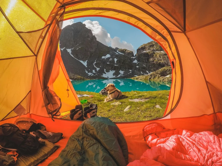 an orange tent has its opening wide to reveal the inside of it