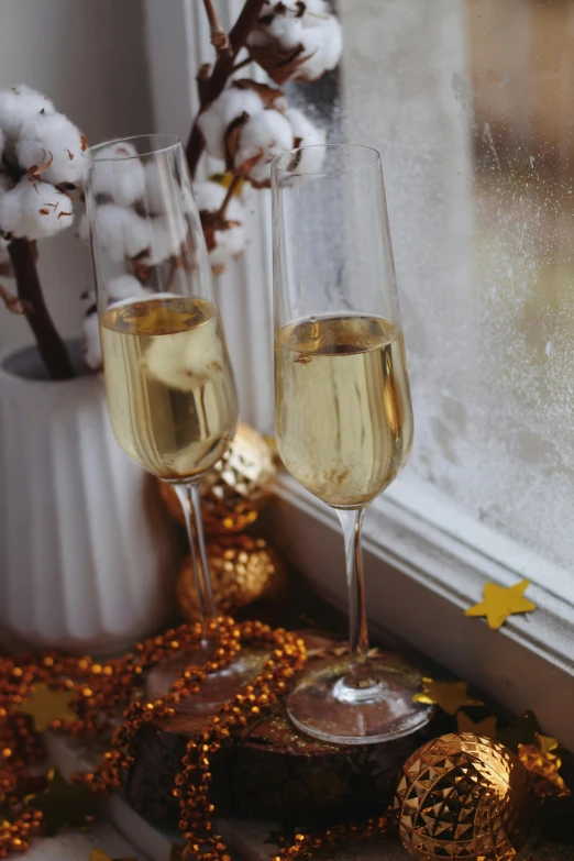 two glasses of champagne are sitting in front of a window