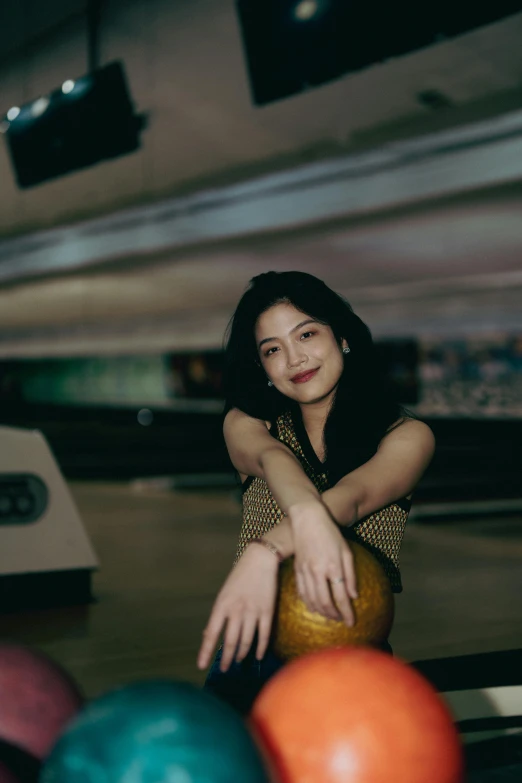 a woman leaning over while bowling down a bowling alley