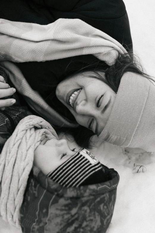 a couple of people laying on the ground under a blanket