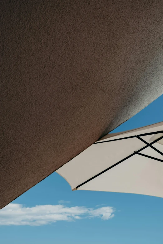 two beach umbrellas sitting side by side outside