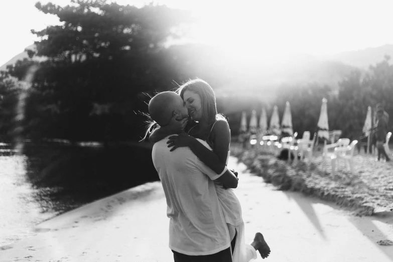 a woman emcing a man from behind near a park