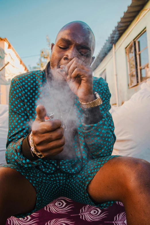 an african american man smokes a cigar while sitting outside