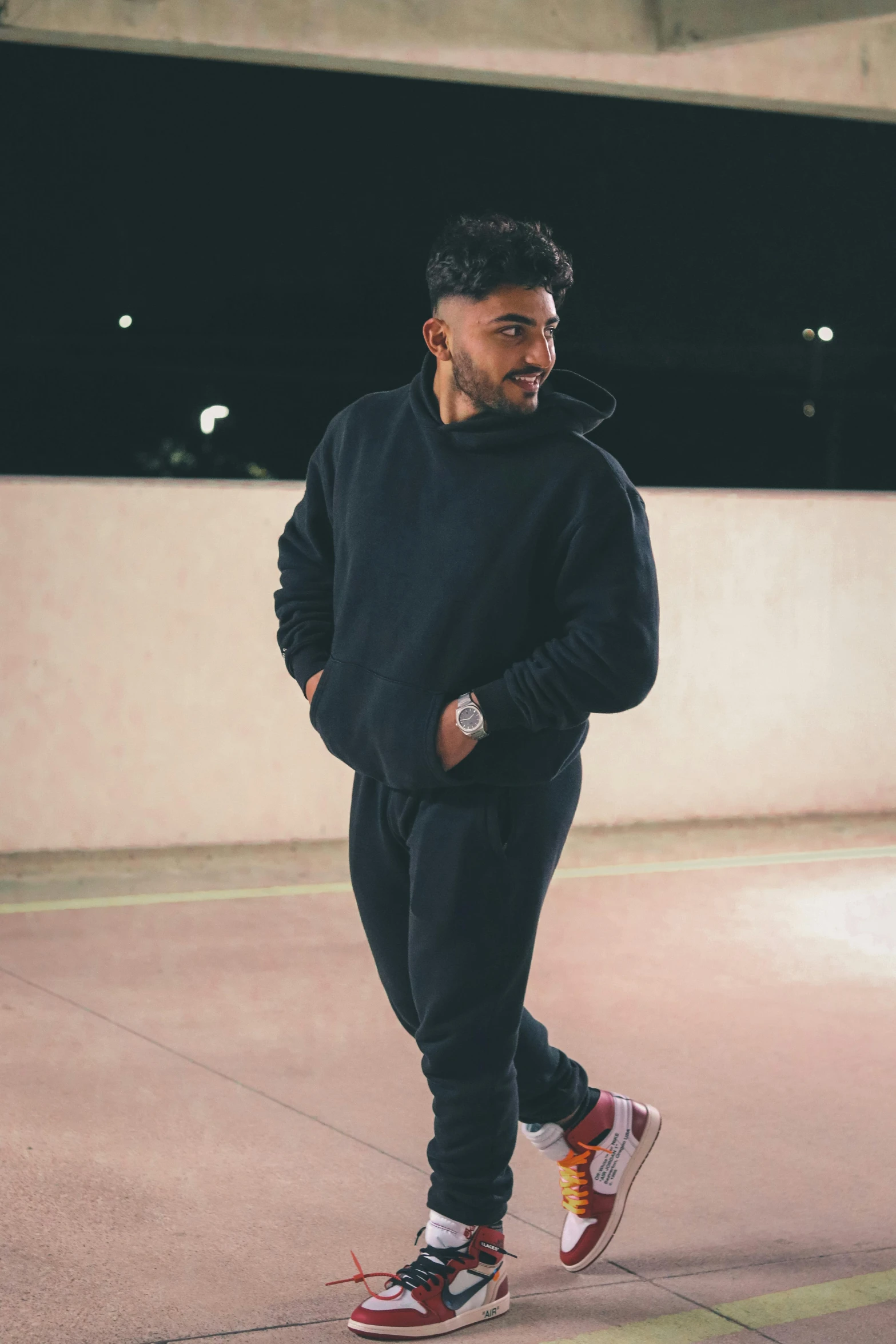 man in black sweat suit standing on sidewalk