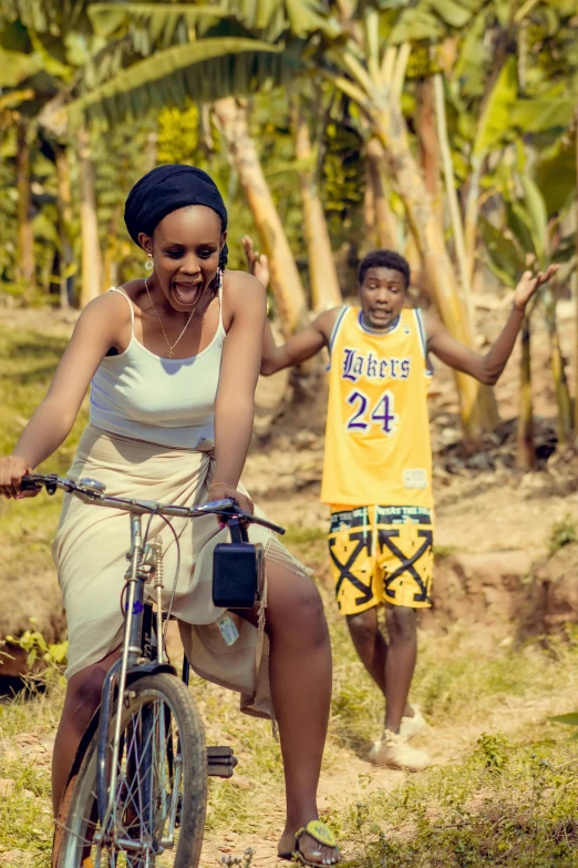 the man is holding hands up next to the girl on a bike