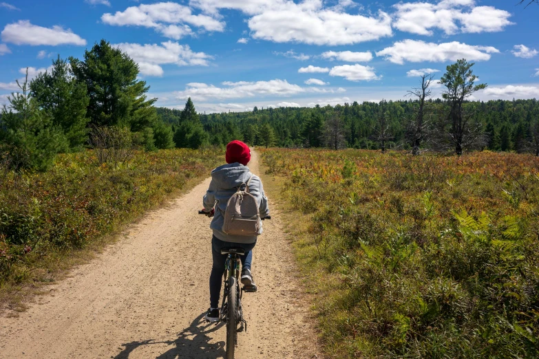 a person riding on the back of a bike down a dirt road