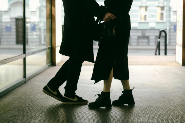 two people touching their hands under an umbrella