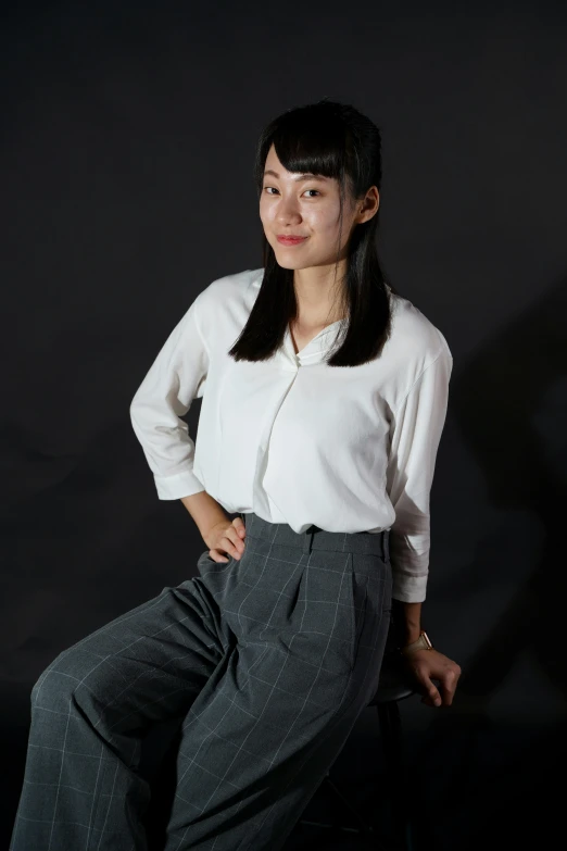 a woman posing for a picture while sitting on a chair