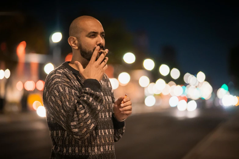 a man standing on the sidewalk with his hand in his mouth