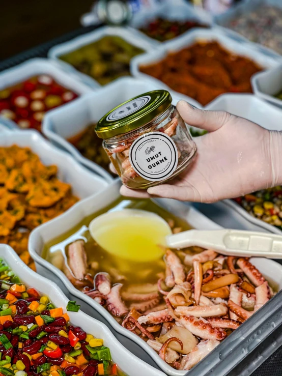 a person picking up some ingredients from a tray