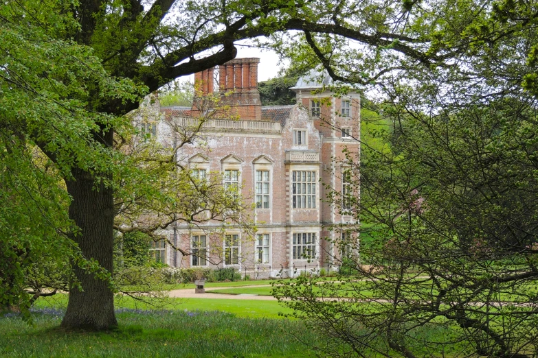 a large castle like building sitting on the side of a lush green field