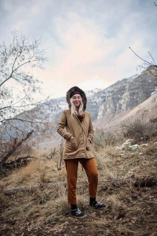 a young person standing on a hill with a field in the background