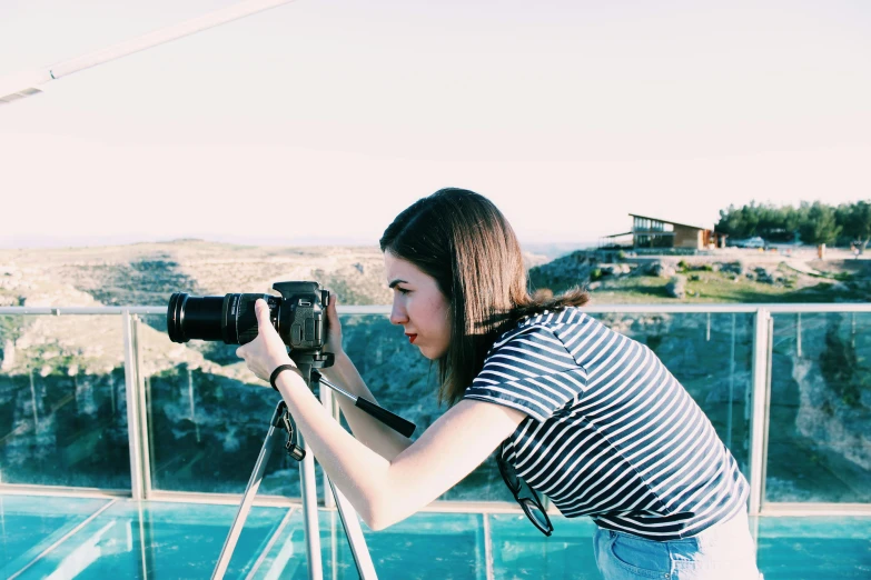 a woman taking a po with a camera on top of a skyscr