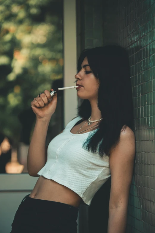 the woman is smoking a cigarette wearing a white shirt
