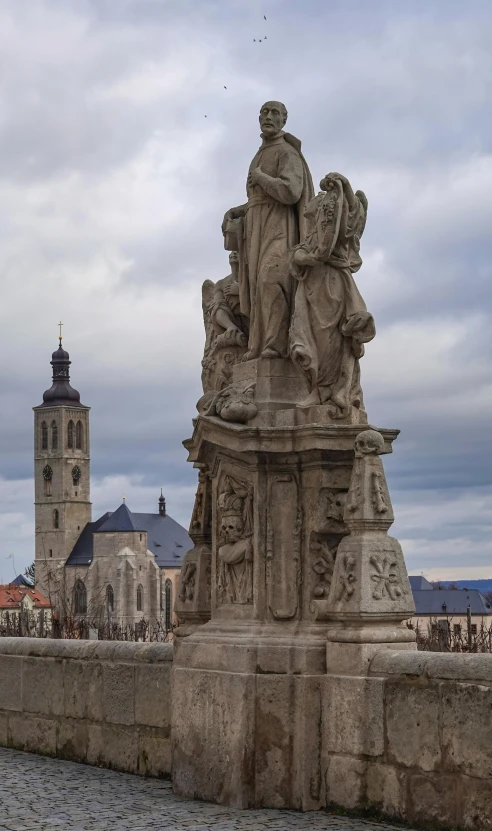 a large clock tower sitting above a statue on top of a cement structure