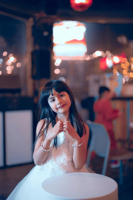 a girl wearing a wedding dress poses for the camera