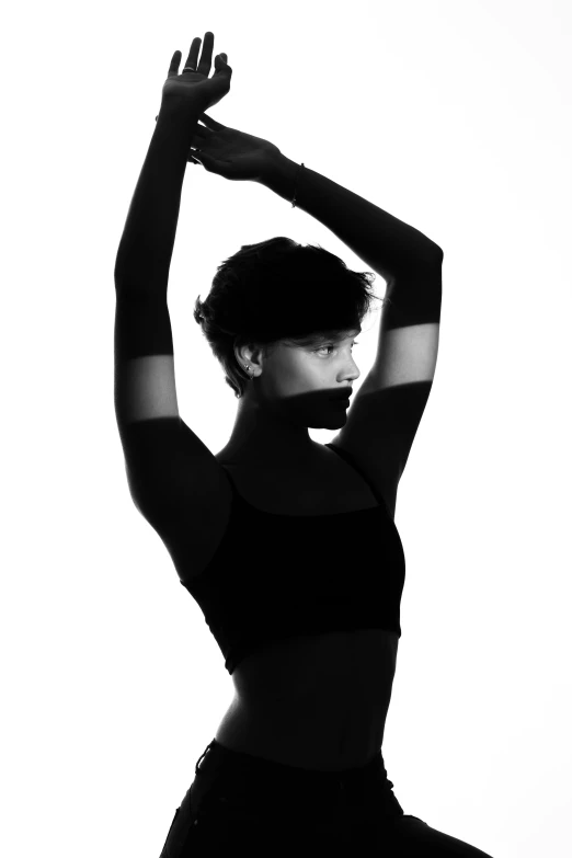 a woman in a black outfit stretching her arm up
