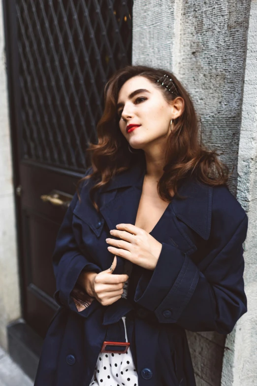 a woman standing next to a black door