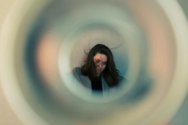 woman looks down through the ring of a sculpture