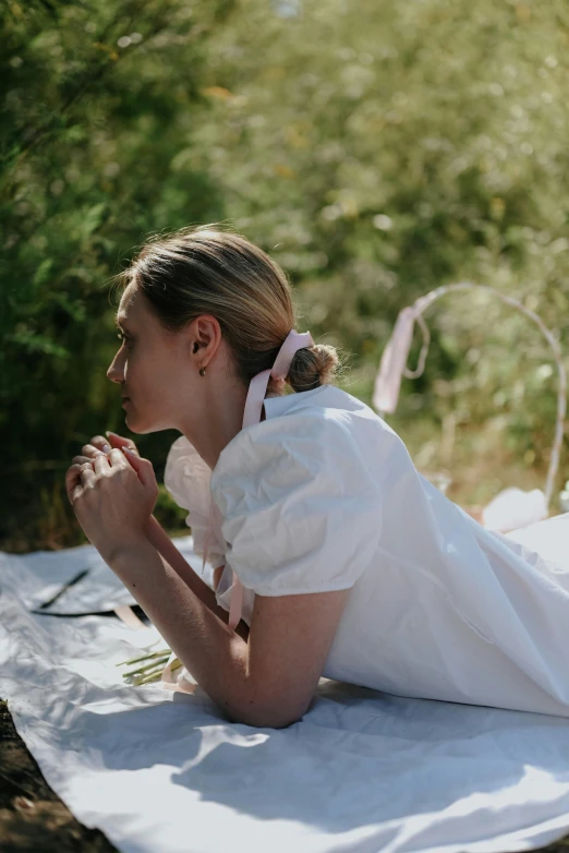 a bride sitting on top of a white sheet