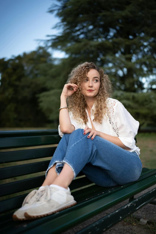 the girl is sitting down on the bench