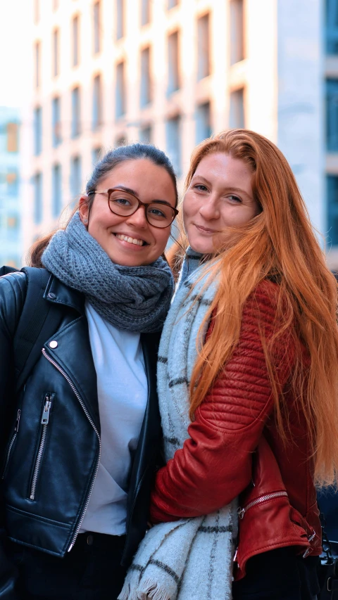 two beautiful women standing next to each other outside