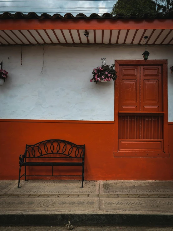 a bench sits outside in front of a painted wall